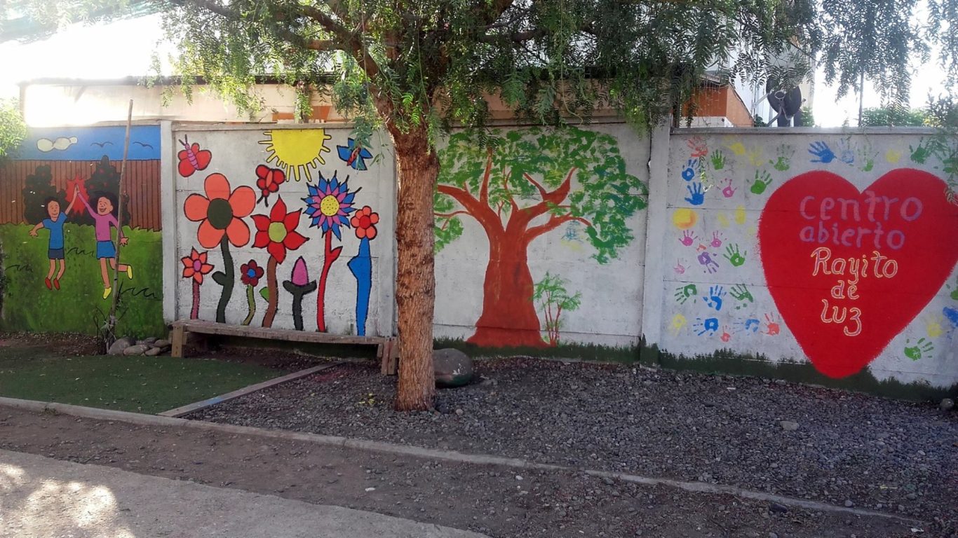 Bunte Wandmalereien mit Blumen, Bäumen und Figuren im Freien.