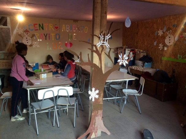 Kinder arbeiten an Tischen in einem gemütlichen Raum mit einem Bastelbaum.